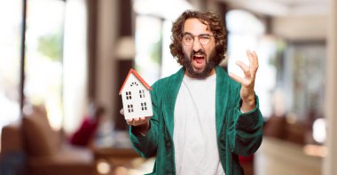 Evde bornoz giyen genç adam.