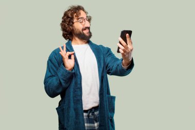 Bornoz giyip gece elbisesi giyen genç bir adam.