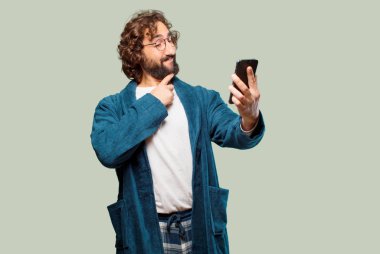 Bornoz giyip gece elbisesi giyen genç bir adam.