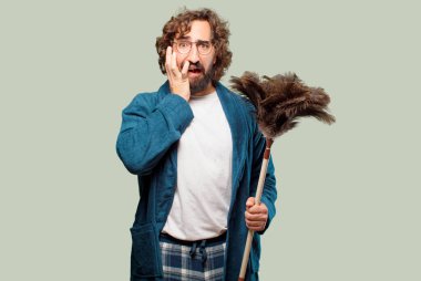 Bornoz giyip, toz bezi giyen genç adam.