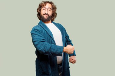 Bornoz giyen genç adam, meydan okuma pozu.