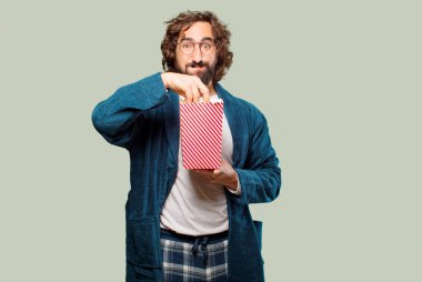 Bornoz giyip, üzerinde patlamış mısır kovası olan genç adam.