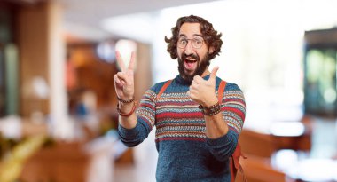 Zafer işareti olan genç hippi adam.