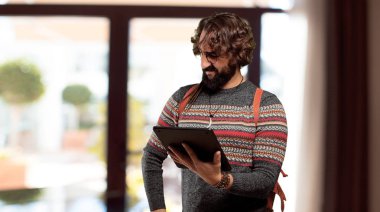 Tabletli genç hippi adam.