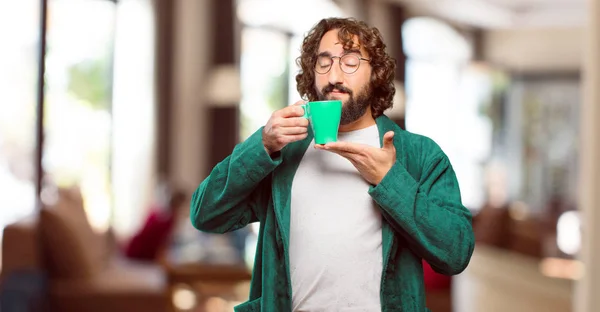 バスローブを着た若い男がコーヒーを飲みながら — ストック写真