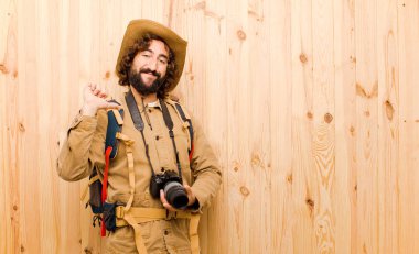 ahşap arka planda saman şapka ve sırt çantası ile genç çılgın Explorer