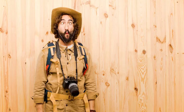 年轻的疯狂的探险家与草帽和背包在木材背景 — 图库照片