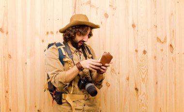 ahşap arka planda saman şapka ve sırt çantası ile genç çılgın Explorer