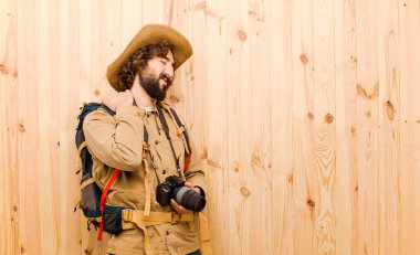 ahşap arka planda saman şapka ve sırt çantası ile genç çılgın Explorer