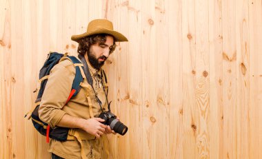 ahşap arka planda saman şapka ve sırt çantası ile genç çılgın Explorer