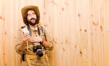 ahşap arka planda saman şapka ve sırt çantası ile genç çılgın Explorer