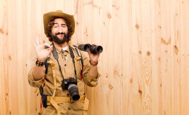 ahşap arka planda saman şapka ve sırt çantası ile genç çılgın Explorer