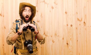 ahşap arka planda saman şapka ve sırt çantası ile genç çılgın Explorer