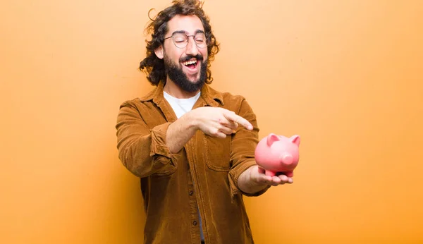 Jovem com cabelo louco em movimento e um mealheiro — Fotografia de Stock