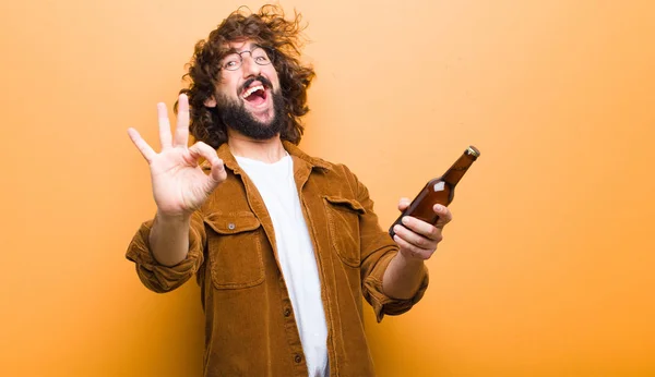 Jeune homme aux cheveux fous en mouvement boire une bière — Photo