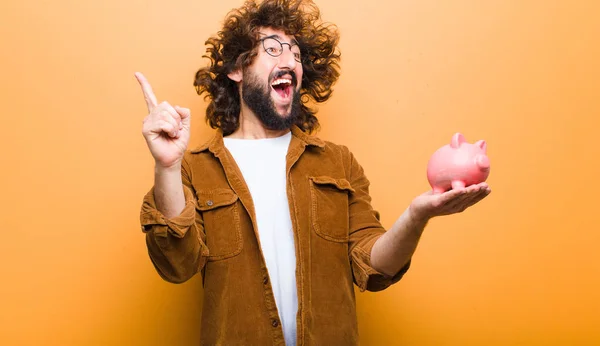 Jovem com cabelo louco em movimento e um mealheiro — Fotografia de Stock