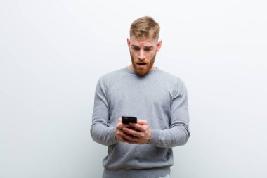 beyaz arka plan karşı bir akıllı telefon ile genç kırmızı kafa adam