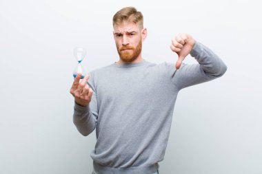 beyaz arka plan karşı bir kum saat zamanlayıcı ile genç kırmızı kafa adam