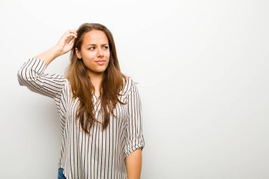 genç kadın şaşkın ve şaşkın duygu, baş kaşıma ve beyaz arka plan karşı yan bakıyor