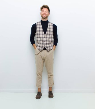 Geniş, eğlenceli, kaçık bir gülüşü ve beyaz arka planda gözleri açık genç bir vücut adamı mutlu ve şapşal görünüyor.