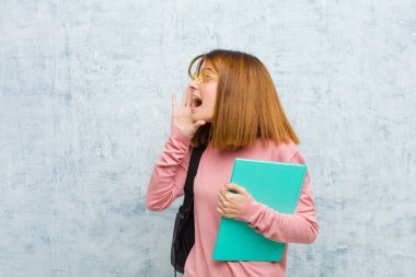 Genç öğrenci kadın profil görüntüsü, mutlu ve heyecanlı görünüyor, bağırıyor ve grunge duvar arka planında yer almak için çağırıyor