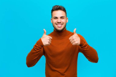 Genç İspanyol adam gülümsüyor. Mutlu, pozitif, kendine güvenen ve başarılı görünüyor.