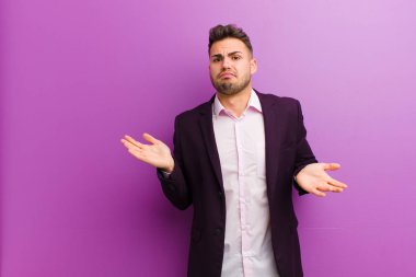 Şaşkın, şaşkın ve stresli görünen genç İspanyol adam farklı seçenekler arasında merak ediyor, kararsız hissediyor.