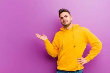 Mor arka planda sıradan görünüşlü genç bir İspanyol.