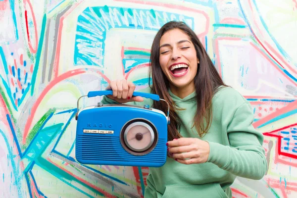 落書き壁に対するヴィンテージラジオを持つ若いかわいい女性 — ストック写真