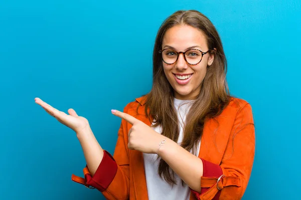 Jovem Mulher Sorrindo Alegremente Apontando Para Copiar Espaço Palma Mão — Fotografia de Stock