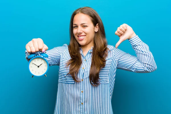 青い背景に対する目覚まし時計を持つ若い女性 — ストック写真