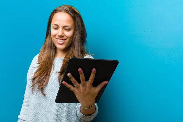 Jeune femme avec une tablette sur fond bleu — Photo