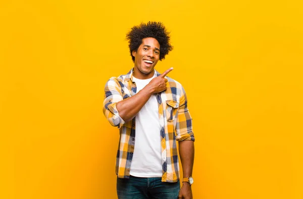 Joven Hombre Negro Sonriendo Alegremente Sintiéndose Feliz Señalando Hacia Lado — Foto de Stock