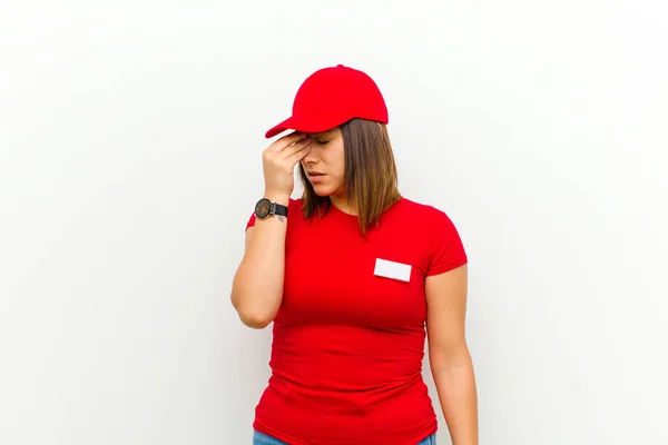 delivery woman feeling stressed, unhappy and frustrated, touching forehead and suffering migraine of severe headache against white background