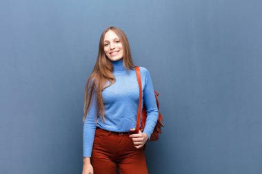 Genç, güzel bir kadın, mavi duvarın karşısında, fotokopi alanı olan.