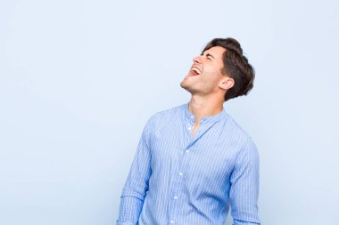 Genç yakışıklı adam öfkeyle bağırıyor, agresif bir şekilde bağırıyor, stresli ve sinirli görünüyor.