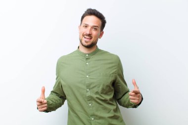 Genç yakışıklı adam gururlu, kibirli, mutlu, şaşırmış ve tatmin olmuş görünüyor, kendini gösteriyor, kazanan gibi hissediyor.