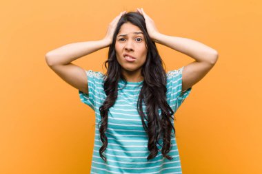 Genç ve güzel İspanyol kadın hayal kırıklığına uğramış ve sıkılmış hissediyor, başarısızlıktan bıkmış ve bıkmış, kahverengi duvara karşı sıkıcı, sıkıcı görevlerden bıkmış