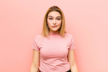 Genç, güzel, sarışın kadın kendini cahil, kafası karışık ve hangi seçeneği seçeceği belirsiz hissediyor. Pembe düz duvara karşı sorunu çözmeye çalışıyor.