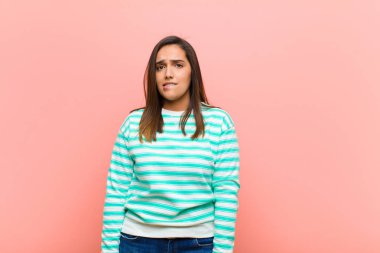 Genç, güzel, İspanyol bir kadın hangi seçeneği seçeceğine karar veremiyor. Pembe duvara karşı sorunu çözmeye çalışıyor.