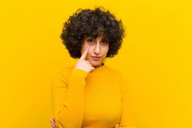 Genç, güzel afro kadın sana göz kulak oluyor, güvenmiyor, izliyor, tetikte ve tetikte.