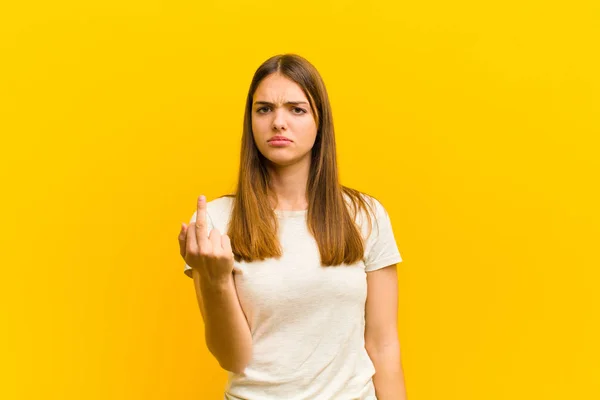 여성은 짜증이 반항적 공격적 손가락의 가운데를 흔들며 주황색 배경에 싸우고 — 스톡 사진