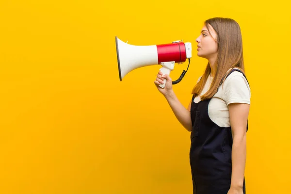 Jong Mooi Vrouw Met Een Megafoon Tegen Oranje Achtergrond — Stockfoto