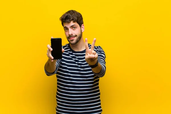 Jovem homem bonito contra fundo laranja — Fotografia de Stock