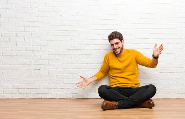 Jovem Homem Bonito Sentado Chão Casa Contra Textura Parede Tijolo — Fotografia de Stock