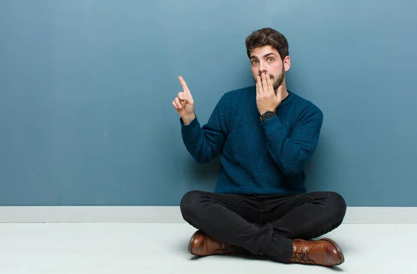 Young Handsome Man Sitting Floor Feeling Happy Shocked Surprised Covering — Stockfoto