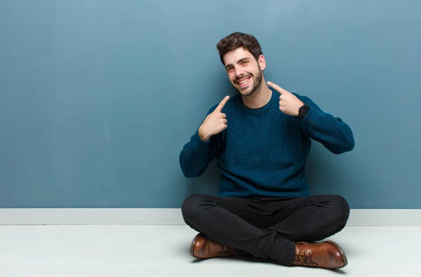 Jovem Homem Bonito Sentado Chão Sorrindo Confiantemente Apontando Para Próprio — Fotografia de Stock