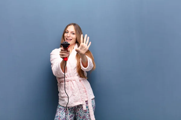 Young Pretty Woman Wearing Pajamas Holding Hairdresser Blue Wall Copy — Stock Photo, Image