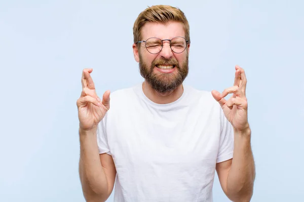 Junger Blonder Erwachsener Mann Lächelt Und Drückt Ängstlich Beide Daumen — Stockfoto