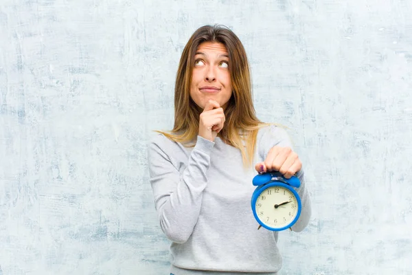 Jong Mooi Vrouw Met Een Wekker Tegen Grunge Muur — Stockfoto